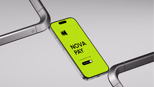 A close-up view of a bright green smartphone lying flat on a surface between two silver devices. The phone screen displays the text 'NOW OR NEVER' in bold black letters